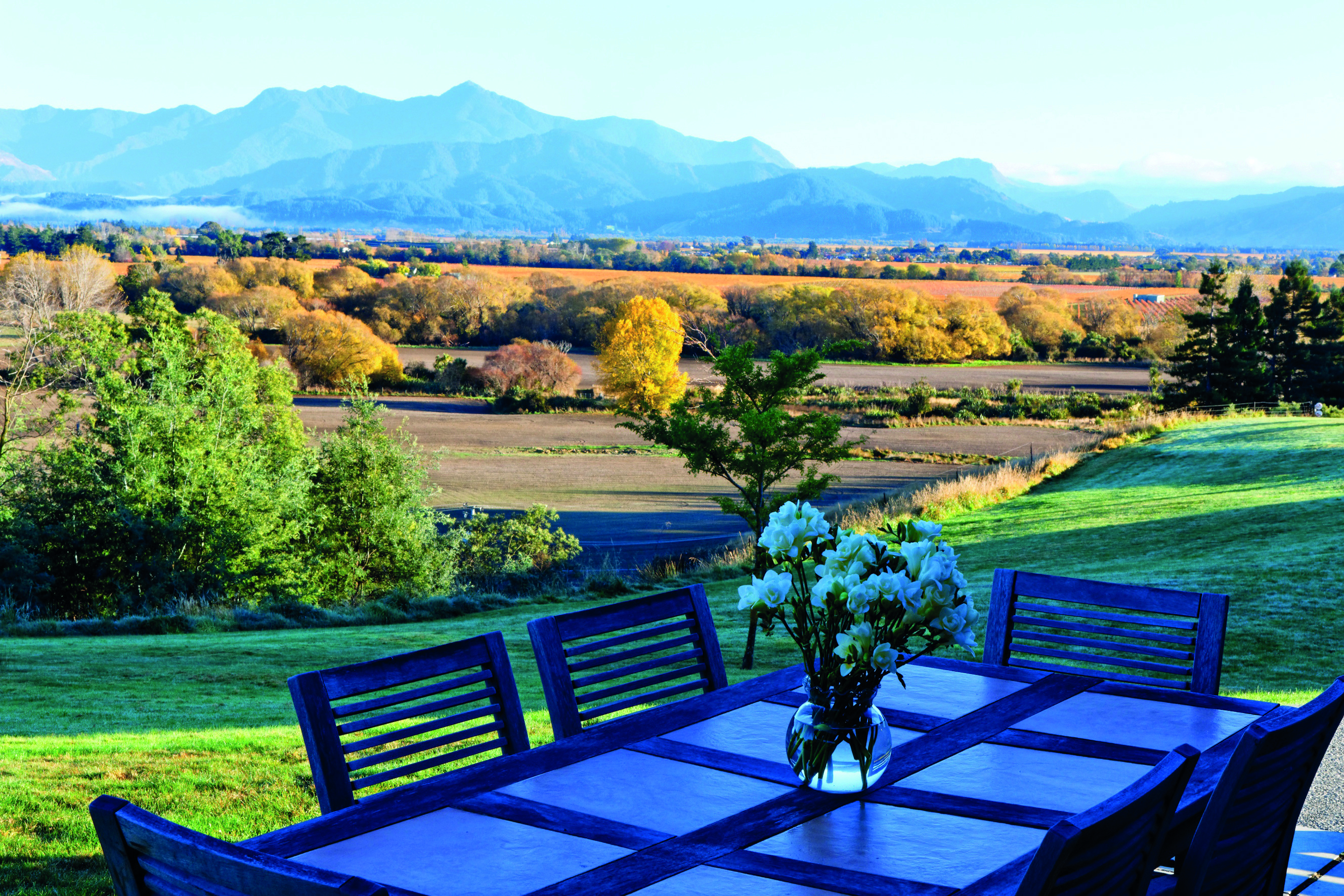 The Bell Tower on Dog Point Blenheim and Marlborough French Barn table with flowers overlooking countryside