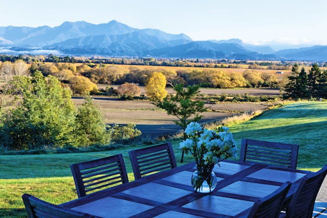 The Bell Tower on Dog Point Blenheim and Marlborough French Barn table with flowers overlooking countryside