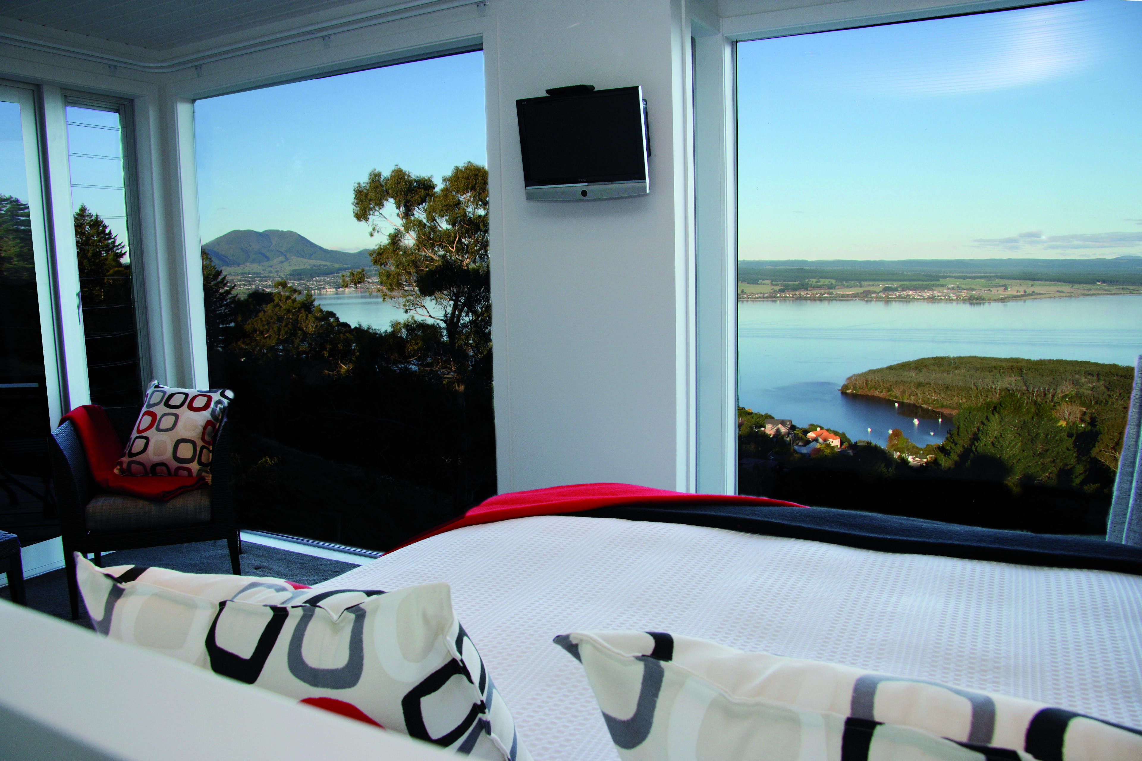 Acacia Cliffs Lodge Central North Island bedroom with large windows and coast view