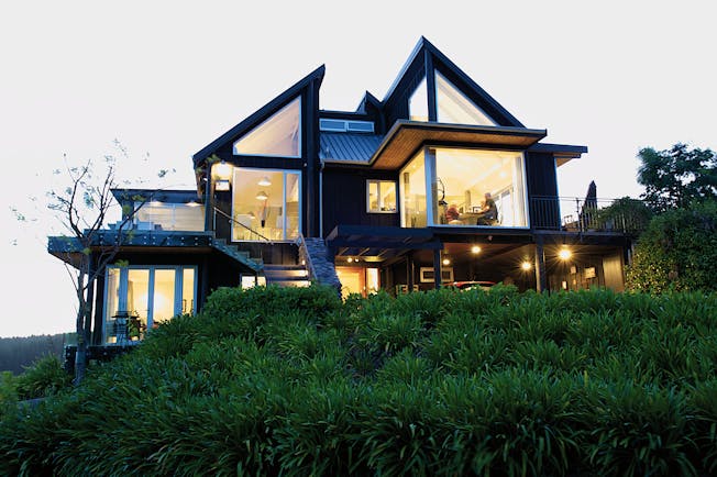 Acacia Cliffs Lodge Central North Island outside modern building with large lit up windows