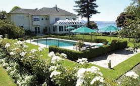Black Swan Boutique Hotel Central North Island exterior white building overlooking outdoor swimming pool and garden 