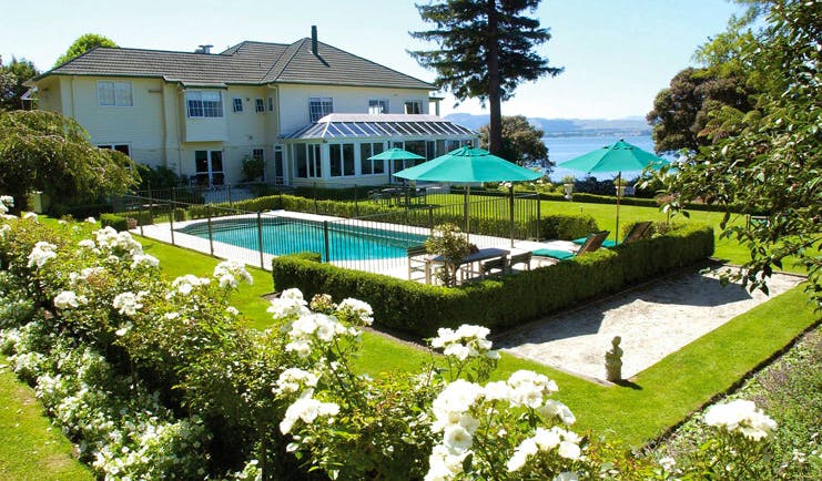 Black Swan Boutique Hotel Central North Island exterior white building overlooking outdoor swimming pool and garden 