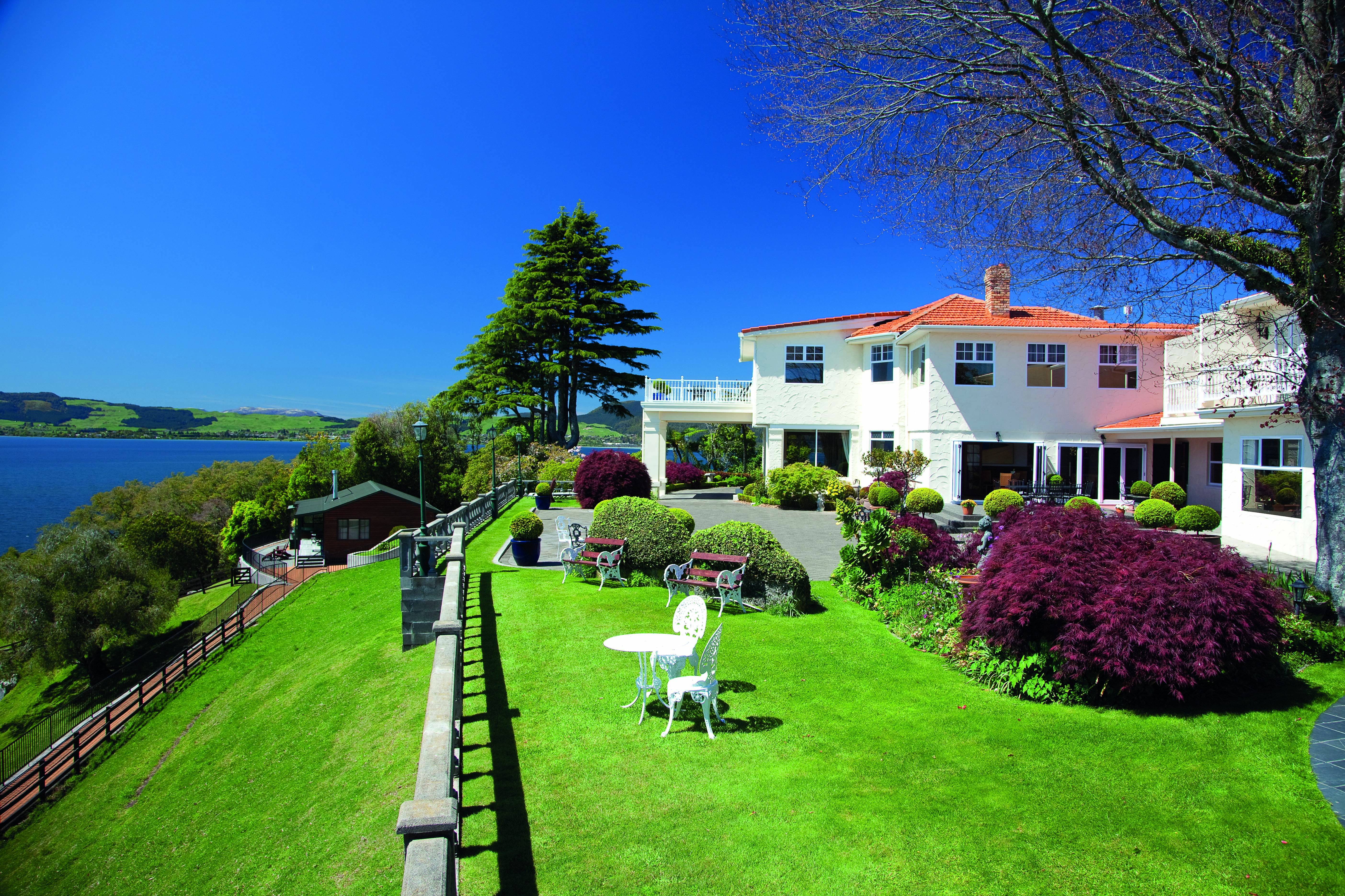 Peppers on the Point Central North Island garden white metal chairs and tables in garden overlooking lake