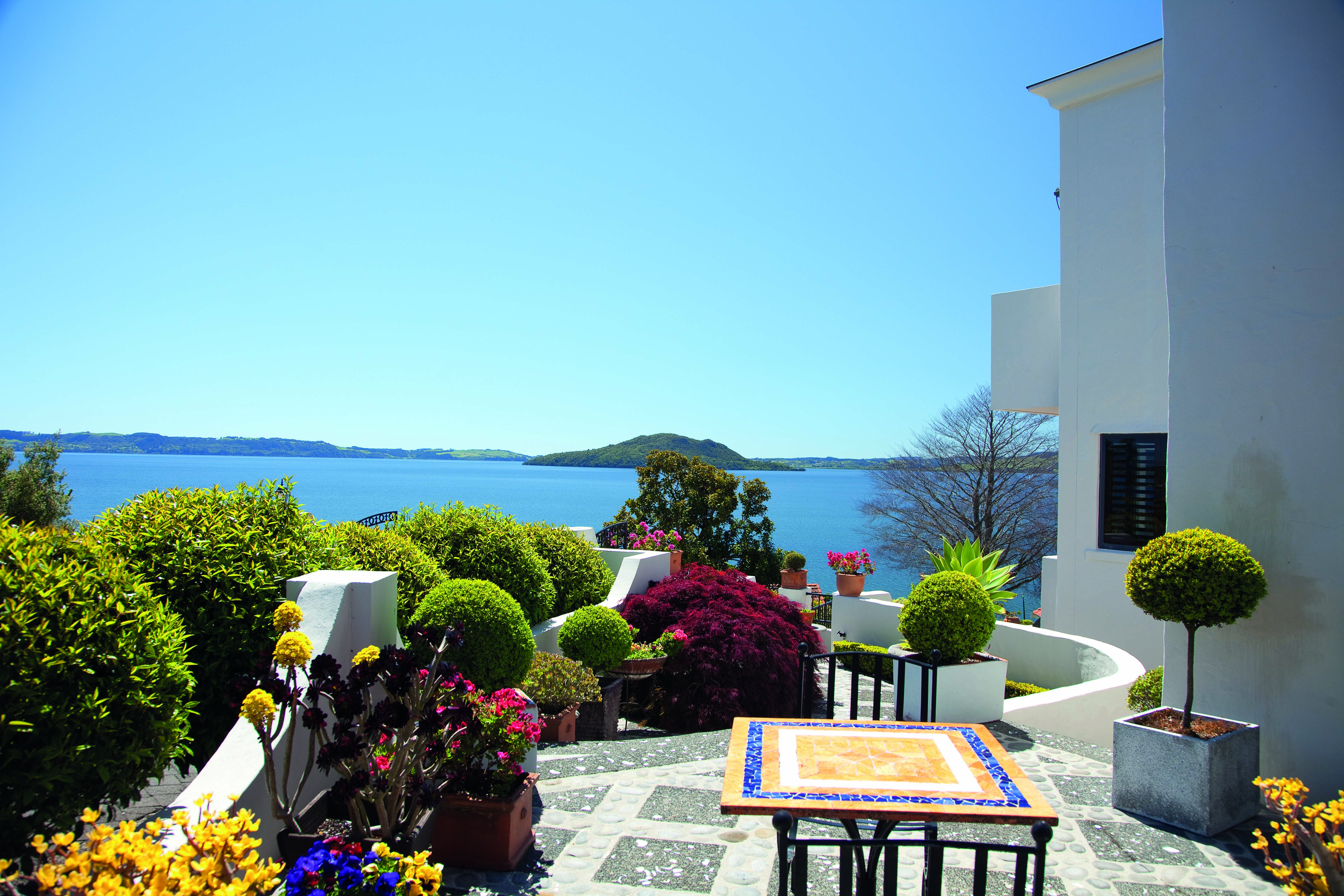 Peppers on the Point Central North Island terrace courtyard with mosaic table and flowers and lake view