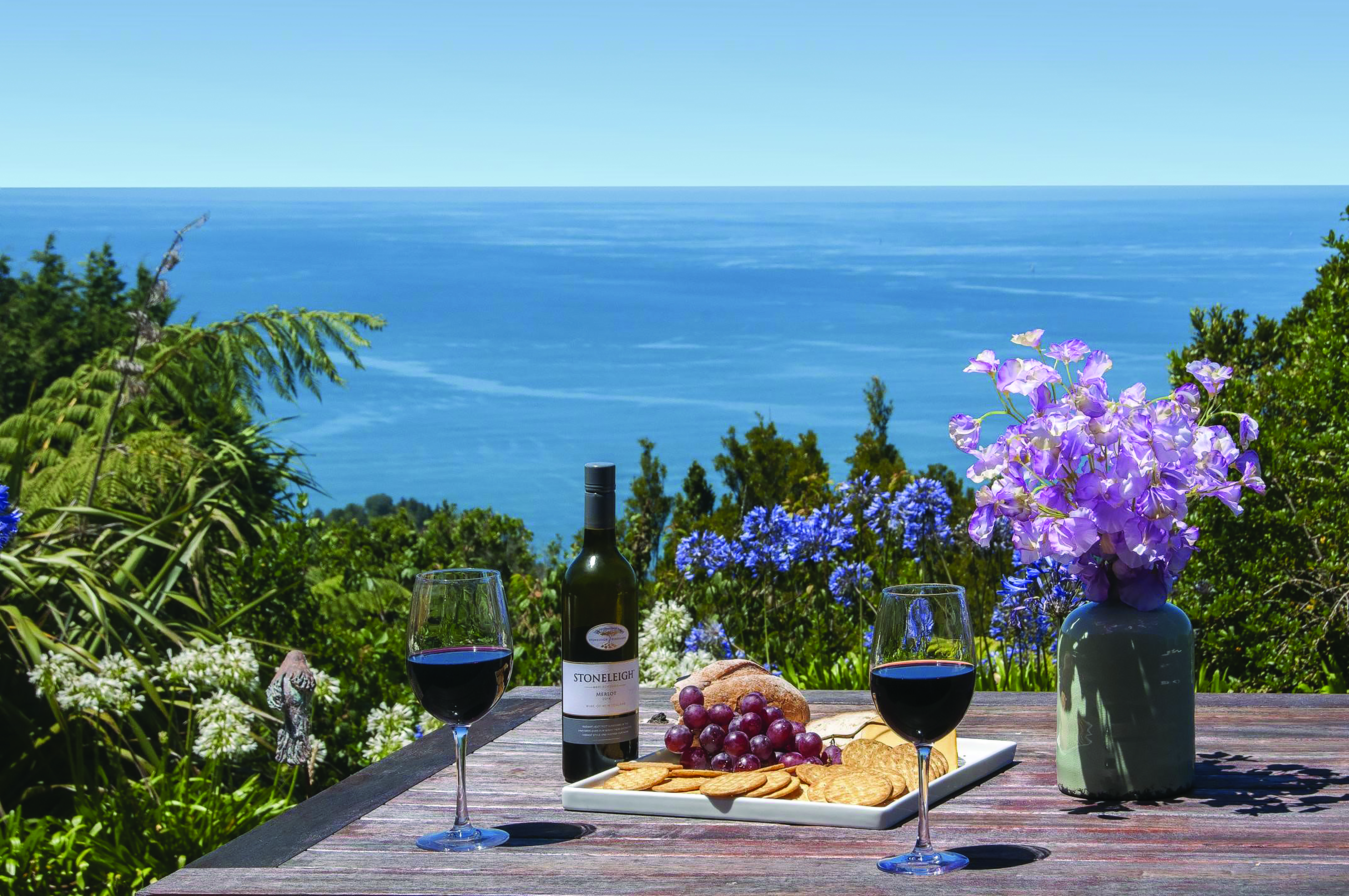 Poets Corner Lodge terrace, wine and cheese board on table, view overlooking the sea