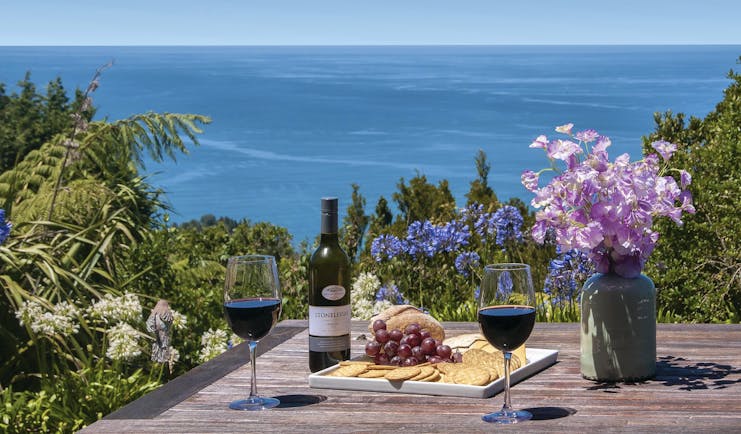 Poets Corner Lodge terrace, wine and cheese board on table, view overlooking the sea