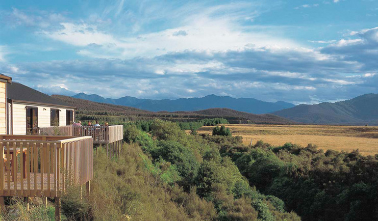 Poronui Ranch Central North Island countryside white lodges with balconies and view of mountains