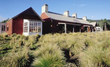 Poronui Ranch Central North Island exterior red lodge building with wild grass