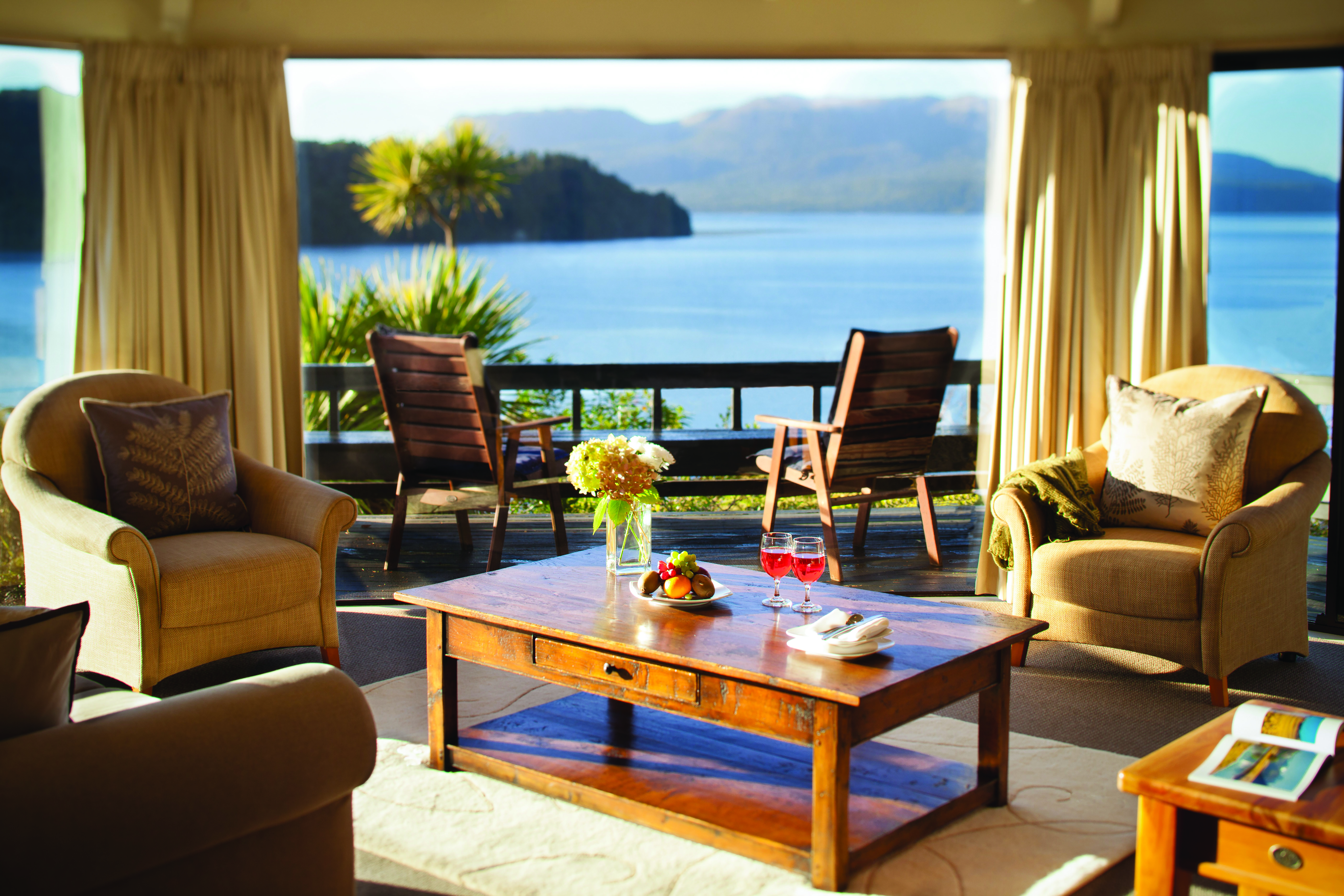 Solitaire Lodge suite, armchairs, coffee table, large windows with view over the sea