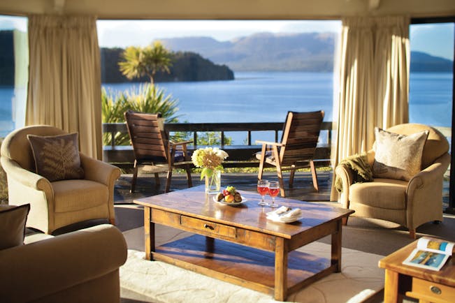 Solitaire Lodge suite, armchairs, coffee table, large windows with view over the sea