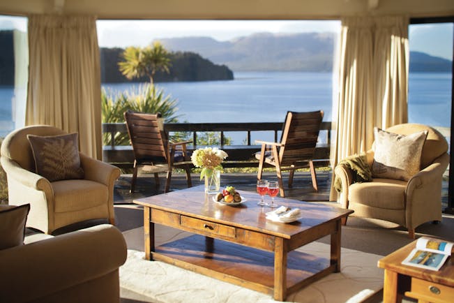 Solitaire Lodge suite, armchairs, coffee table, large windows with view over the sea