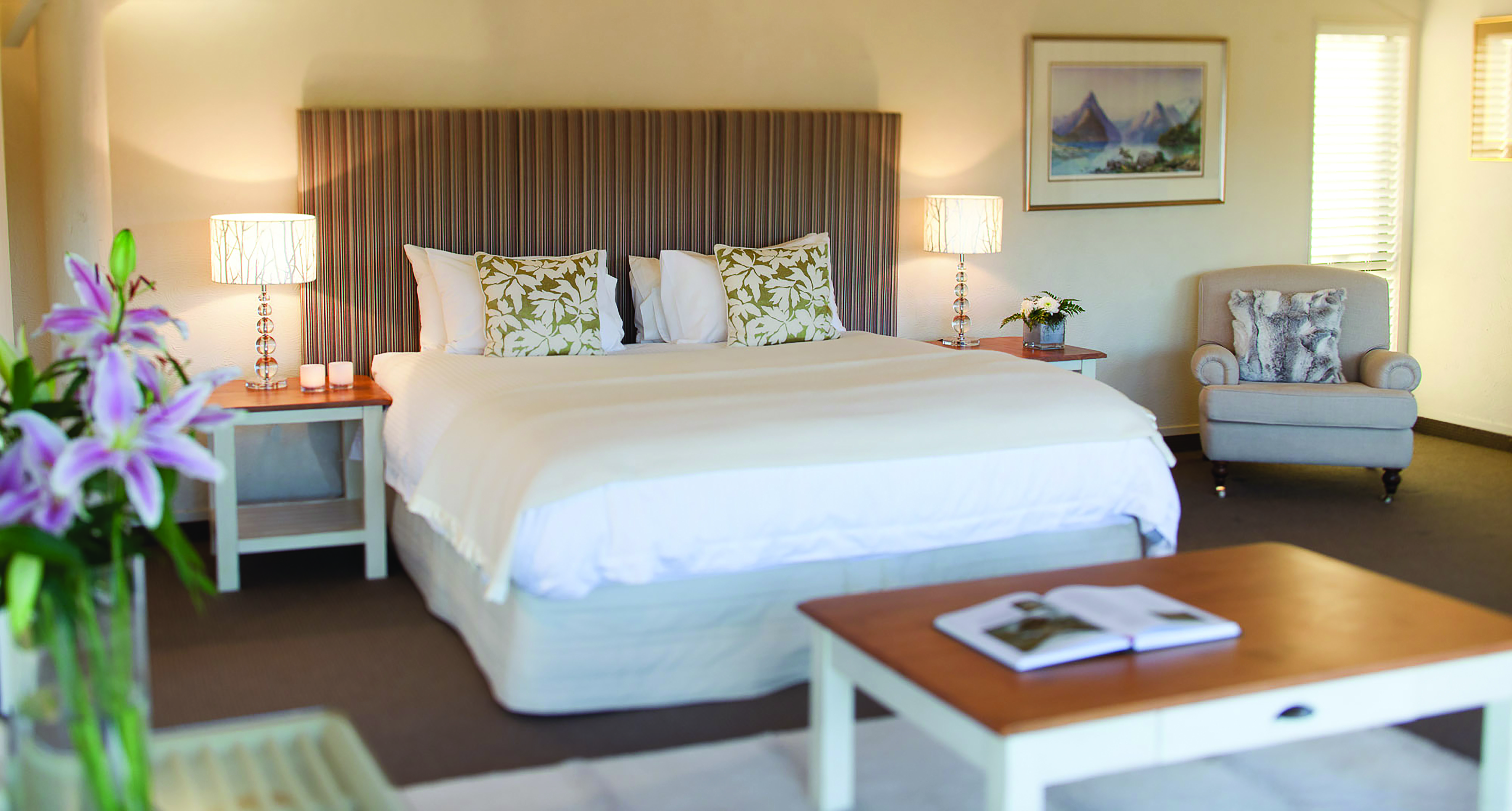Solitaire Lodge Tarawera suite, double bed, armchairs, bright decor