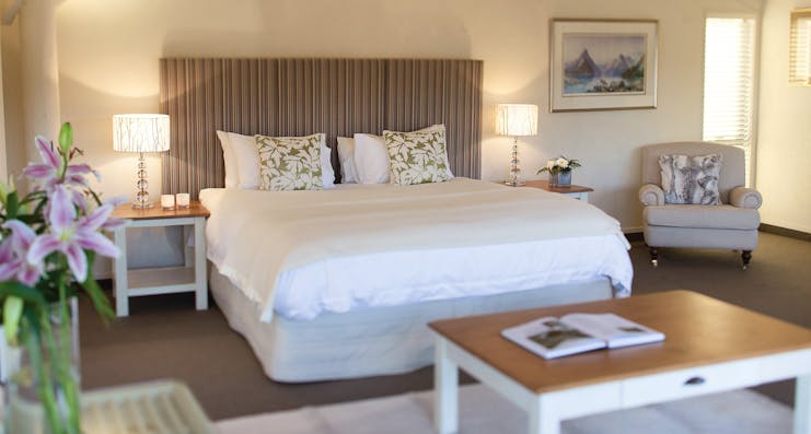 Solitaire Lodge Tarawera suite, double bed, armchairs, bright decor
