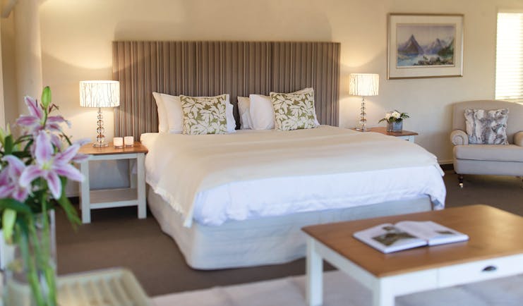 Solitaire Lodge Tarawera suite, double bed, armchairs, bright decor