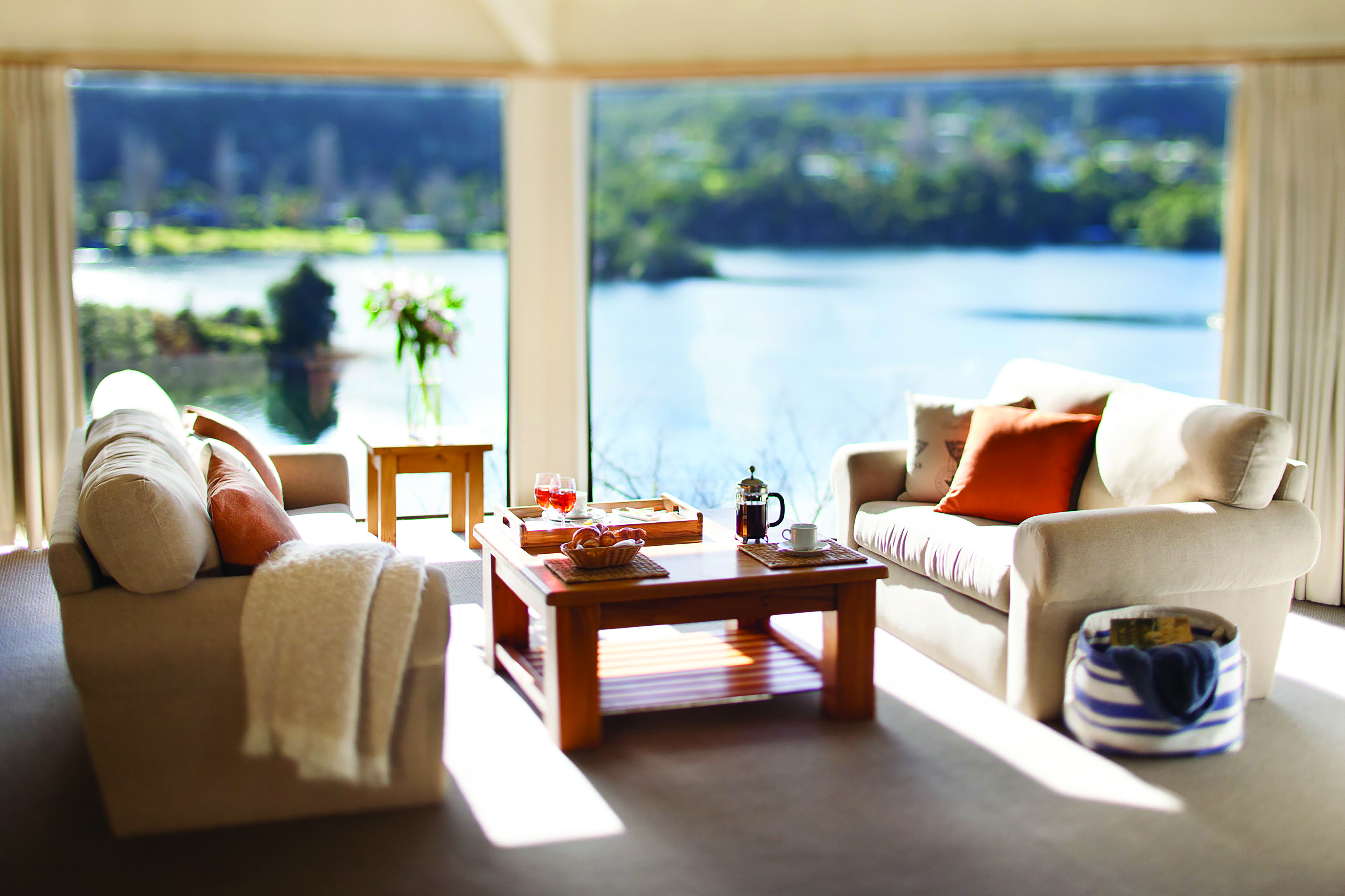 Solitaire Lodge villa suite living area, sofas table, large windows with views over the lakes