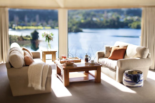 Solitaire Lodge villa suite living area, sofas table, large windows with views over the lakes