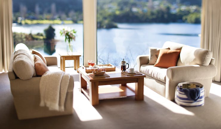 Solitaire Lodge villa suite living area, sofas table, large windows with views over the lakes