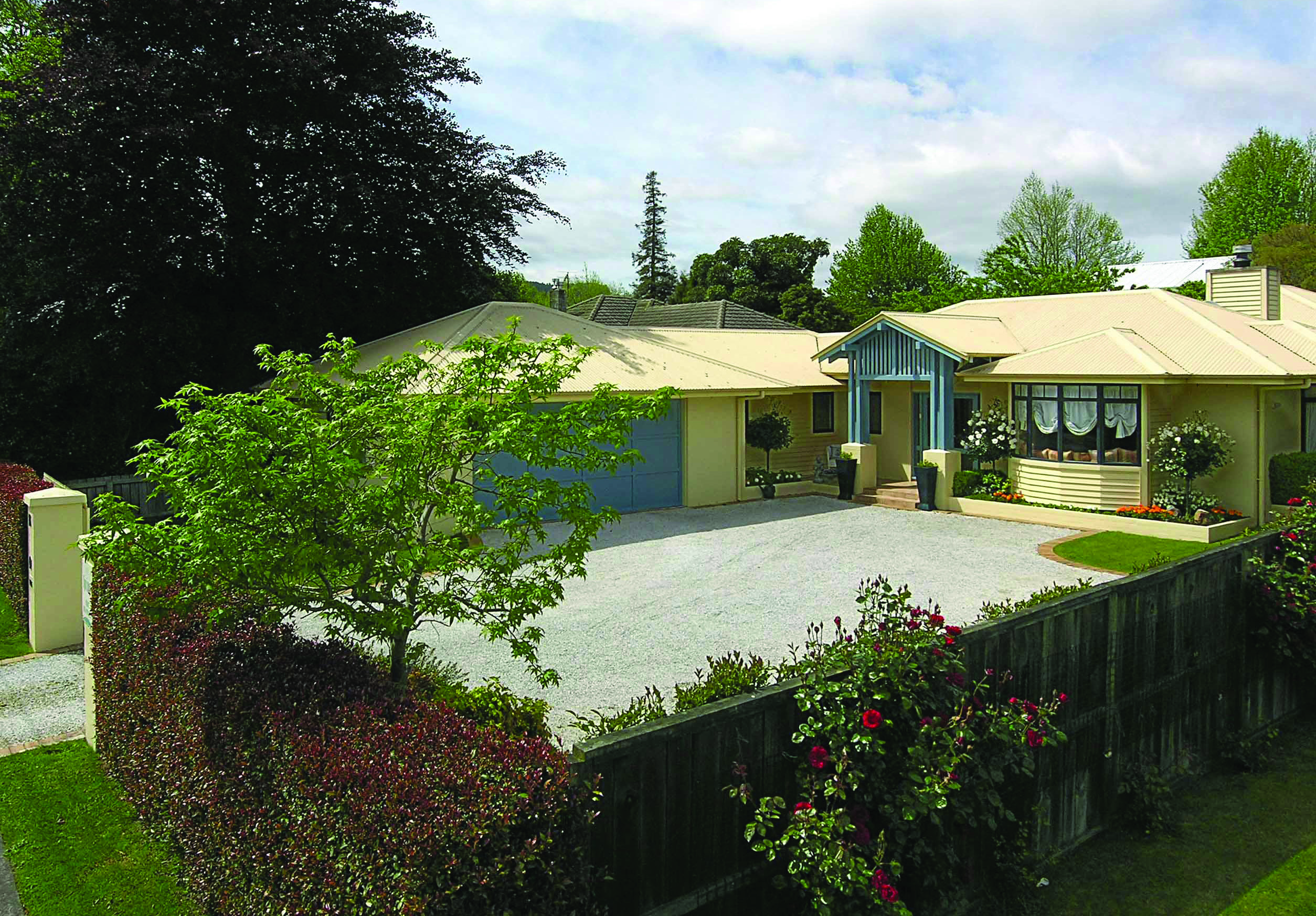View of The Springs from the exterior showing a yellow building surrounded by greenery
