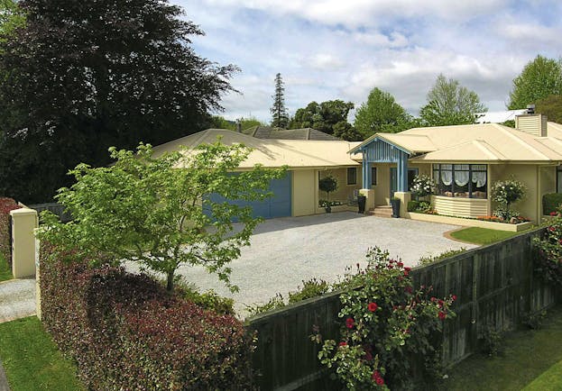 View of The Springs from the exterior showing a yellow building surrounded by greenery