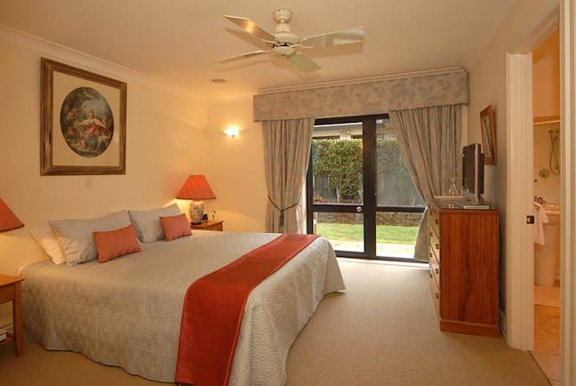 The Springs Central North Island Rachel room bedroom with patio doors garden access and view to bathroom