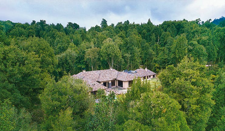 Treetops Lodge Central North Island aerial view of white lodge with grey roof surrounded by forest