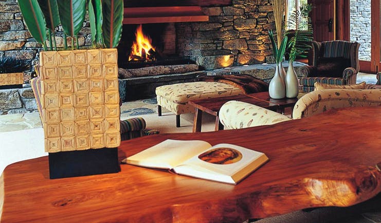 Treetops Lodge Central North Island fireplace lounge area with stone fireplace