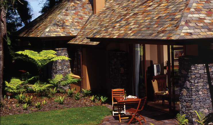 Treetops Lodge Central North Island lodge stone cottage with garden table and two chairs