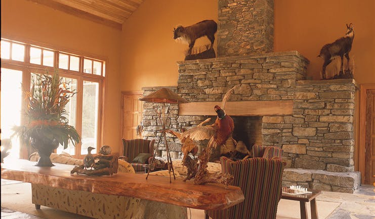 Treetops Lodge Central North Island lounge area with stone fireplace and taxidermy animals