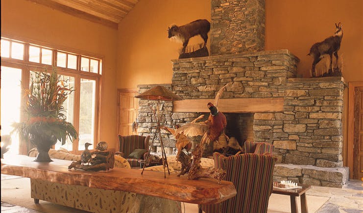 Treetops Lodge Central North Island lounge area with stone fireplace and taxidermy animals