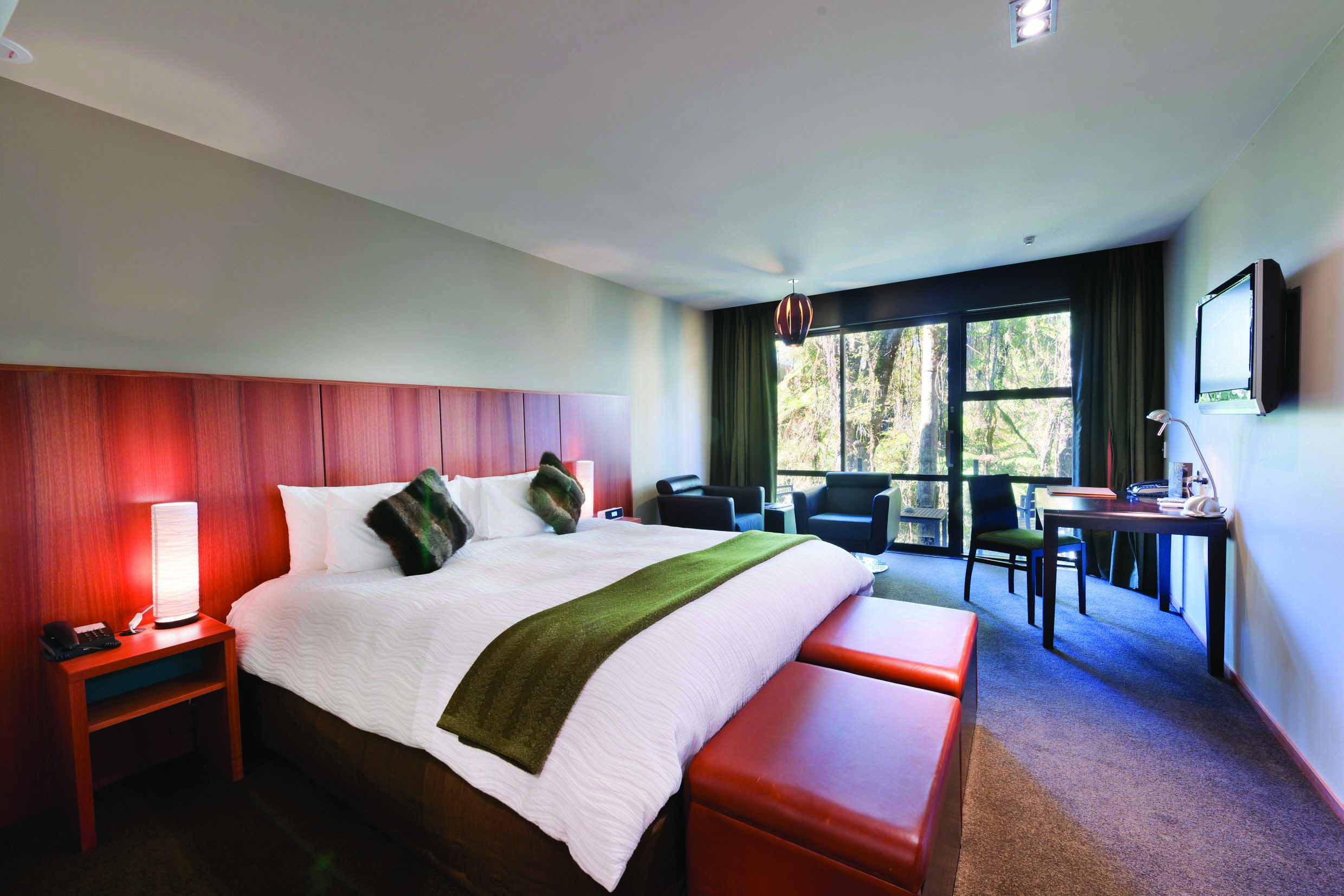 Te Waonui Forest Retreat Central South Island bedroom with seating area and large windows