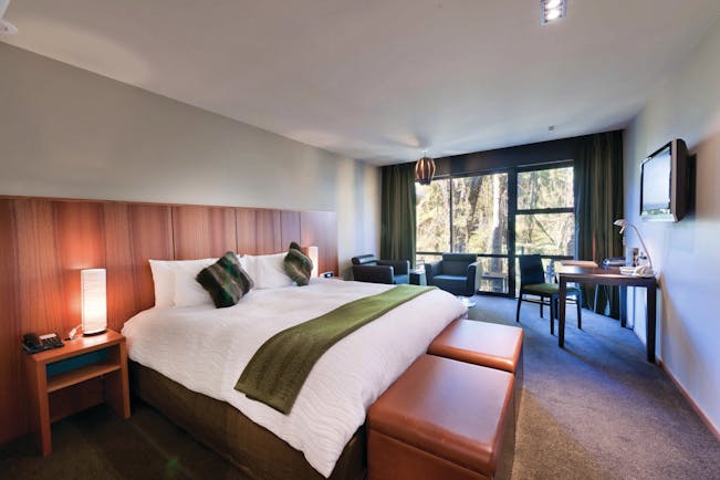Te Waonui Forest Retreat Central South Island bedroom with seating area and large windows