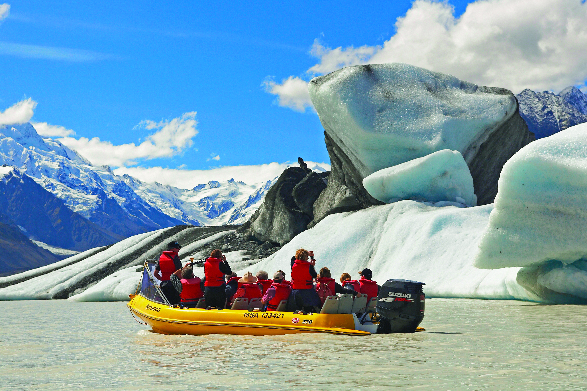 The Hermitage Hotel Central South Island glacier tour people in small boat looking at glacier