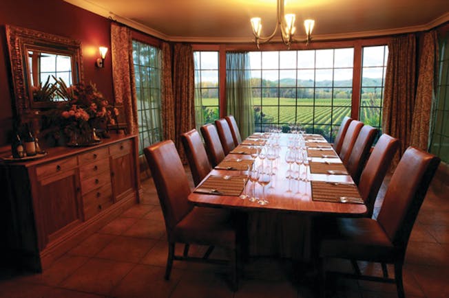 Beckenridge Lodge Hawkes Bay and Napier dining room with large table leather chairs and vineyard view