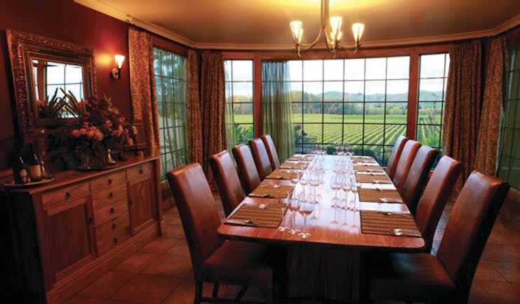 Beckenridge Lodge Hawkes Bay and Napier dining room with large table leather chairs and vineyard view