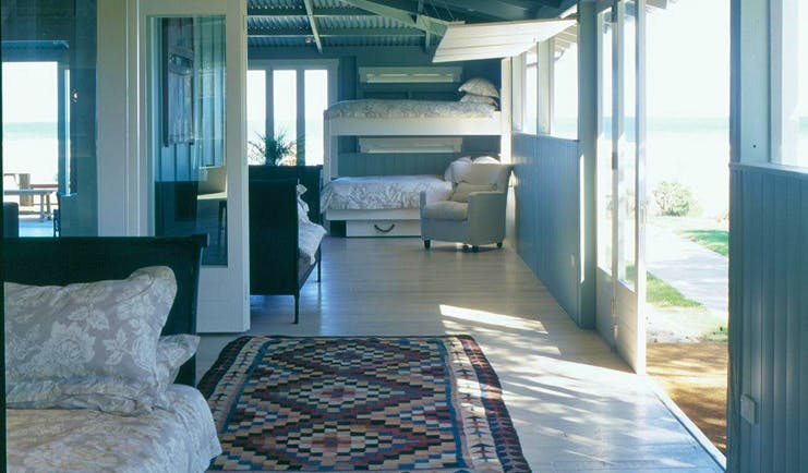 The Black Barn Hawkes Bay beach veranda open plan room with bed and bunk beds 