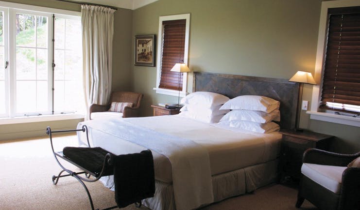 The Black Barn Hawkes Bay bedroom with large windows and armchairs