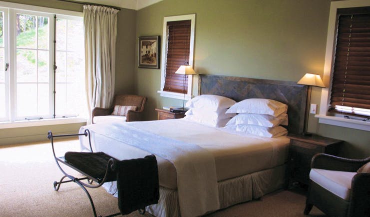The Black Barn Hawkes Bay bedroom with large windows and armchairs