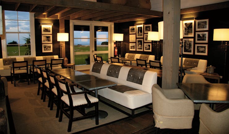 The Farm at Cape Kidnappers Hawkes Bay and Napier clubhouse lounge area with sofas tables with clifftop view