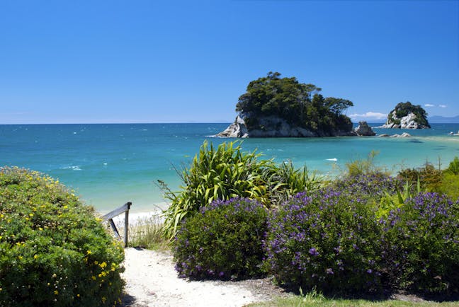 Little Kaiteriteri Beach in Abel Tasman National Park, sand, shrubbery, sea, Torlesse Rock in background