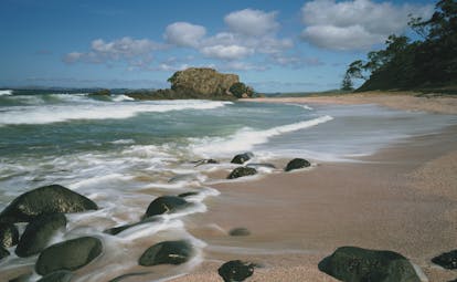 Kauri Cliffs beach, pink sand, blue sea, rocks