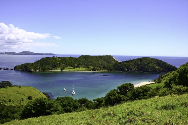 Lonely Bay in the Bay of Islands, verdant greenery, islands, blue seas, boat on water
