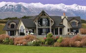 Dock Bay Lodge Otago and Fiordland exterior chalet style building with large windows in front of mountains