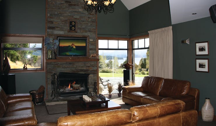 Dock Bay Lodge Otago and Fiordland lounge with leather sofa and fireplace