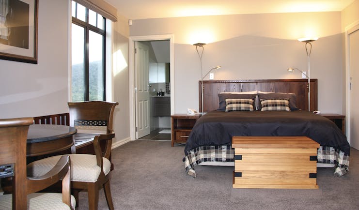 Dock Bay Lodge Otago and Fiordland suite bedroom with large window chair and view to bathroom