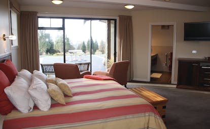 Dock Bay Lodge Otago and Fiordland suite room bedroom with seating area and terrace 