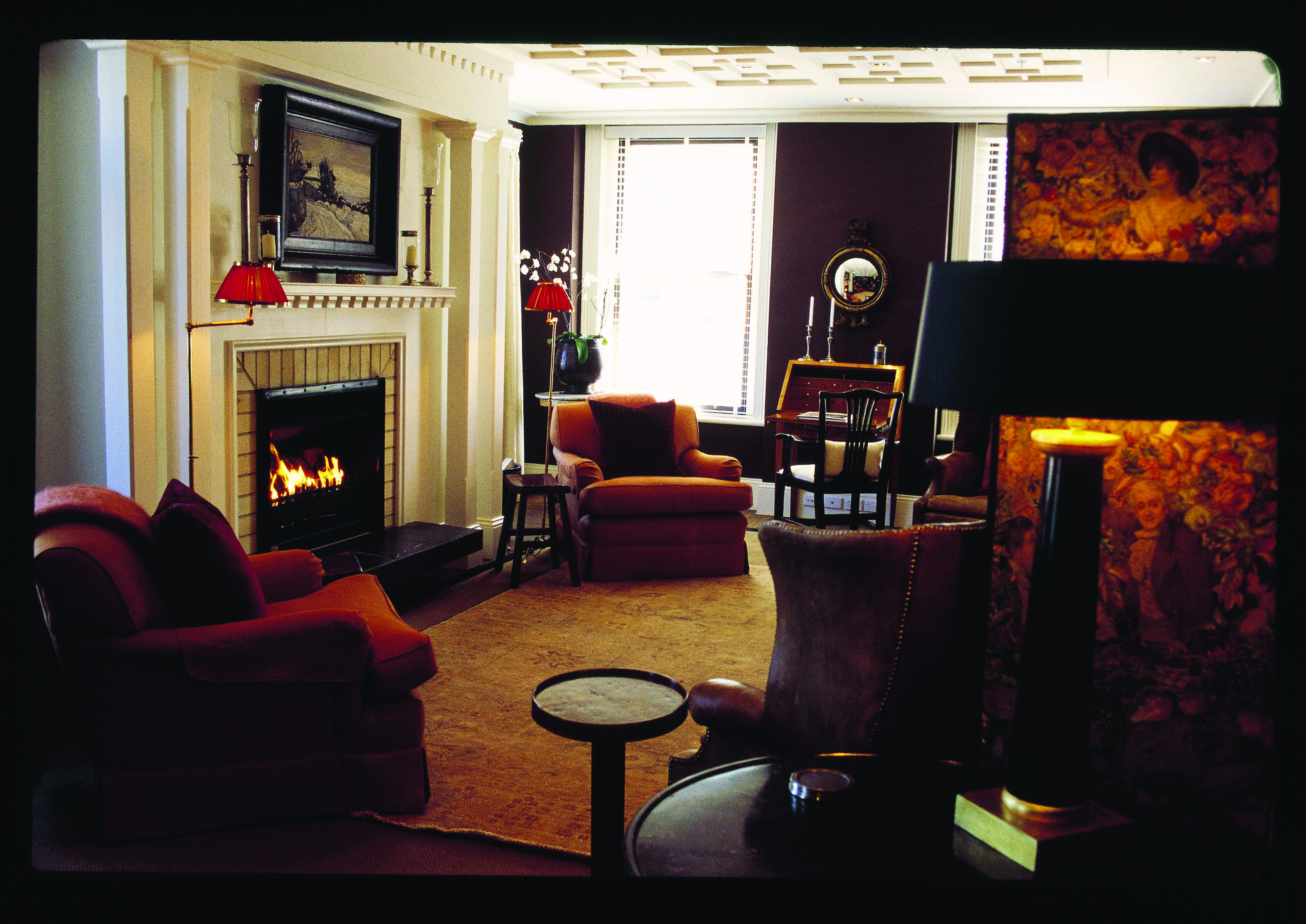 Lounge area ath Eichardt's with a fire place and armchairs around the room 