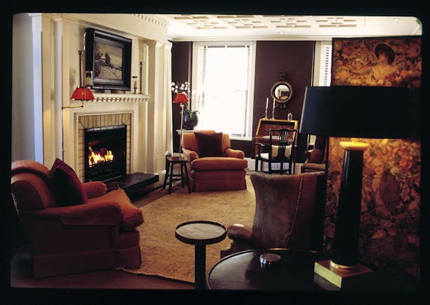 Lounge area ath Eichardt's with a fire place and armchairs around the room 