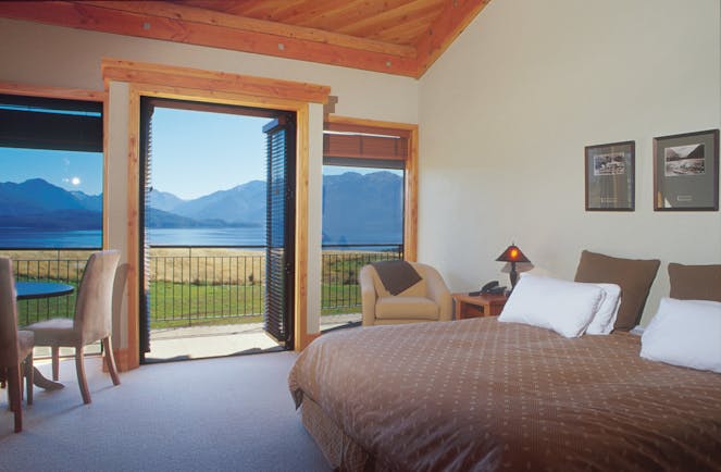 Bedroom with large double bed and doors opening onto a balcony over looking mountains