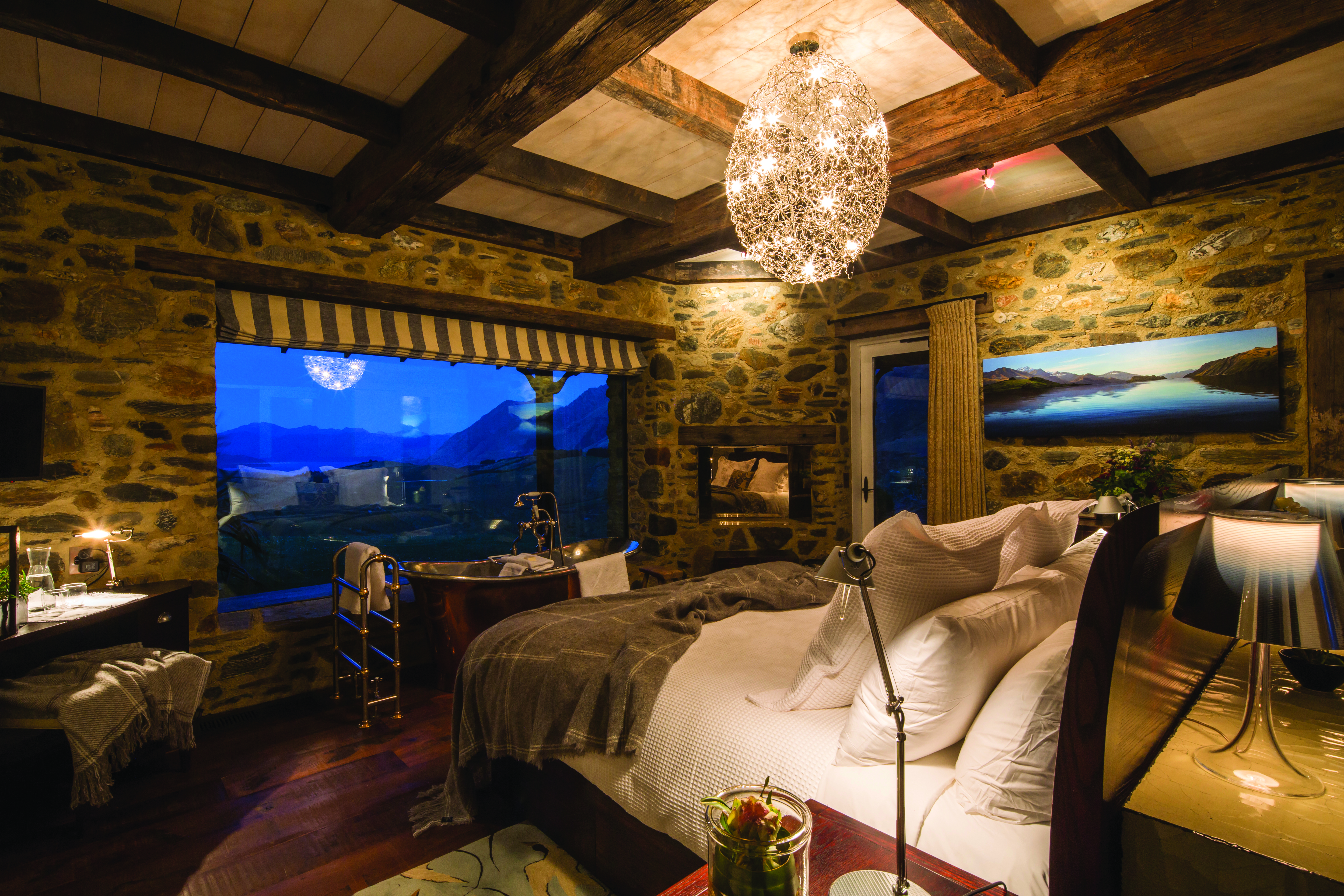 Mahu Whenua Otago and Fiordland bedroom stone walled bedroom with copper bath tub and large window