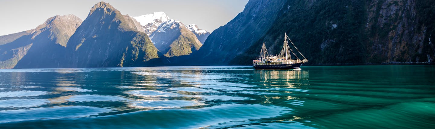 Milford Sound in Fiordland, blue waters, looming mountains